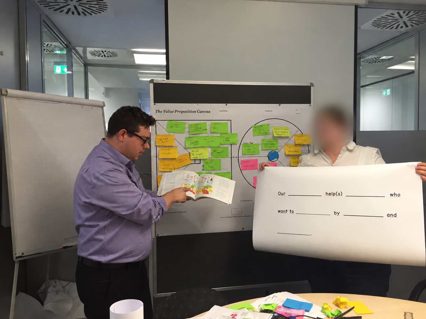 Participants discussing a completed Value Proposition Canvas and a template for value hypotheses